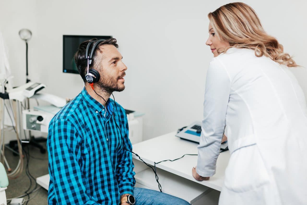 Middle age man at medical examination or checkup in otolaryngologist's office