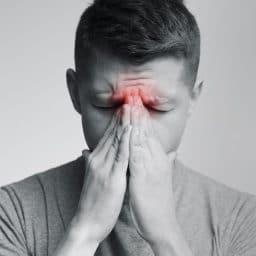 Man experiencing sinus pressure due to allergies.