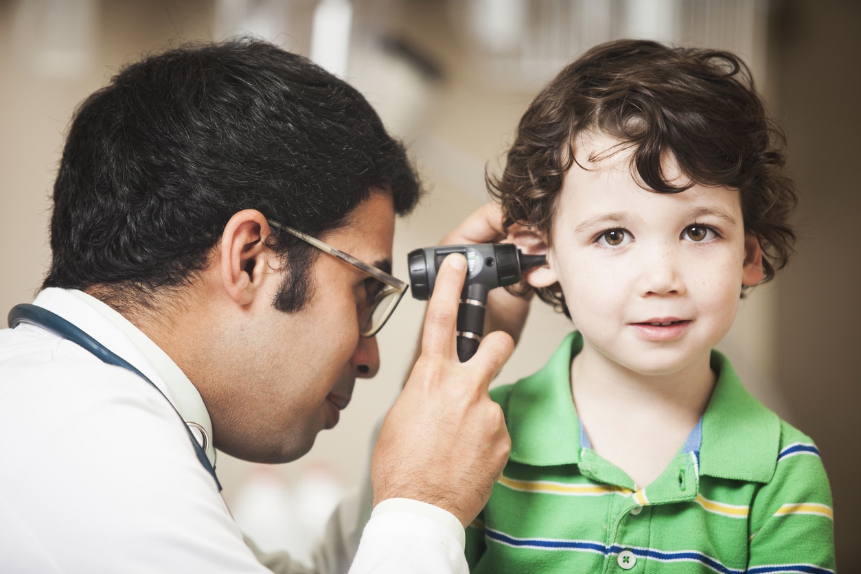 Doctor giving a toddler-aged boy an ear exam.