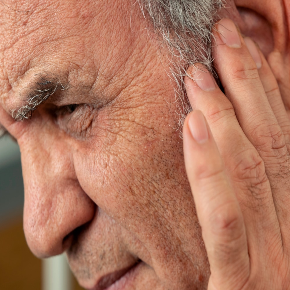 close-up image of a man touching his ear