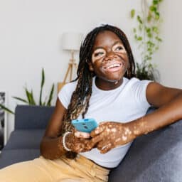 Happy young woman with vitiligo sitting at home