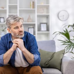 Man on a sofa looking thoughtful