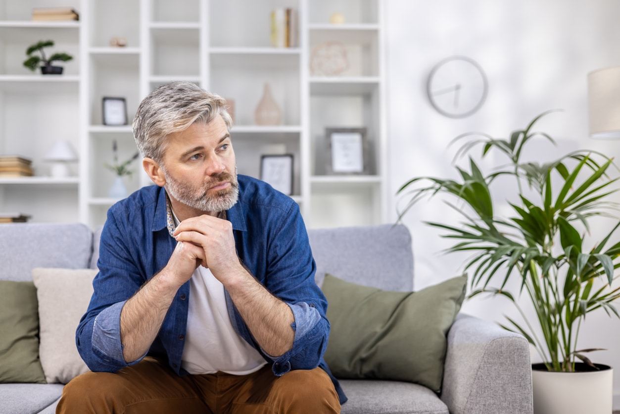 Man on a sofa looking thoughtful