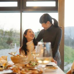 Two woman talking at the Thanksgiving dinner table